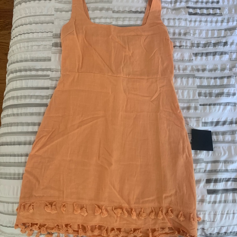 Orange mini dress with tassels along bottom hem from Lulus in size Medium